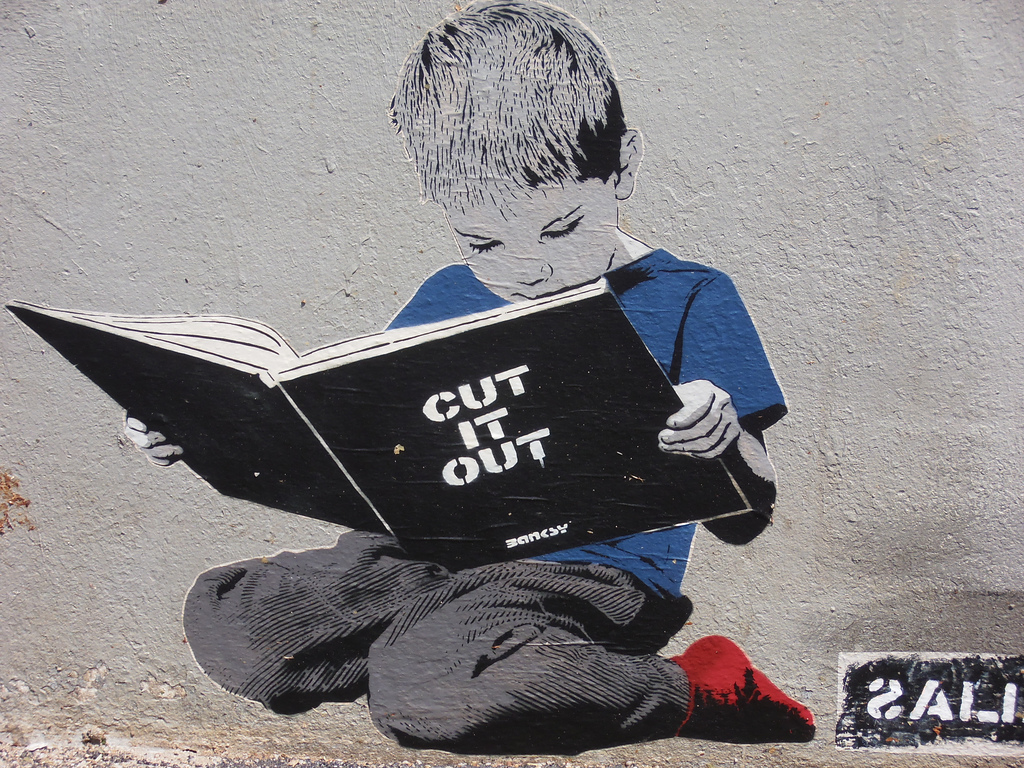 Ménilmontant, Paris. cut it out alias Banksy. A boy's reading